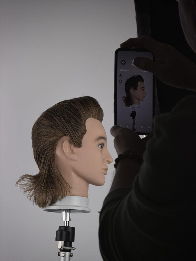 zdjecie wykonanej pracy na główce fryzjerskiej kursant robi zdjęcei aby zbudować portfolio